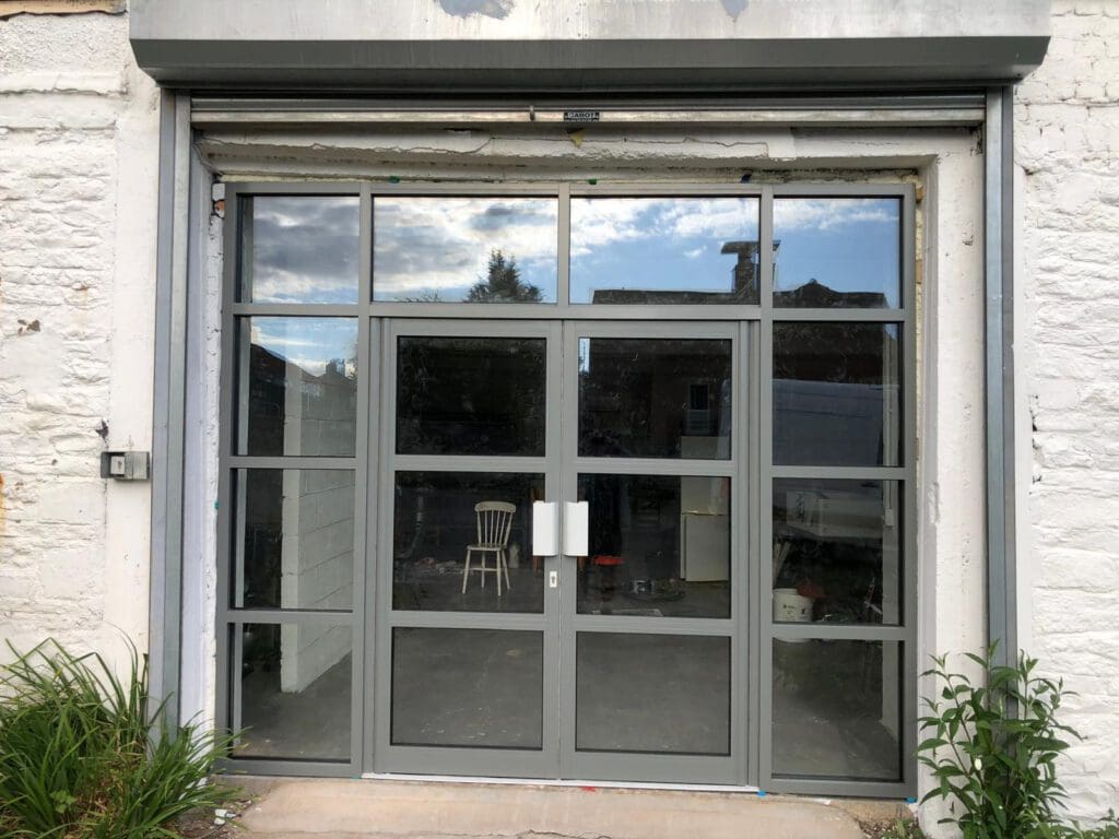 Large grey-framed glass doors set into a white brick wall following structural alterations